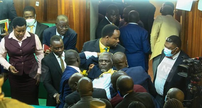 members of parliament help to lift their fellow legislator kwizera out of parliament(curtesy photo)