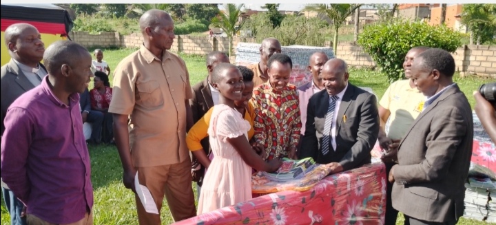 MP Kabasharira, DEO Ntungamo and handing over some items to a pupil