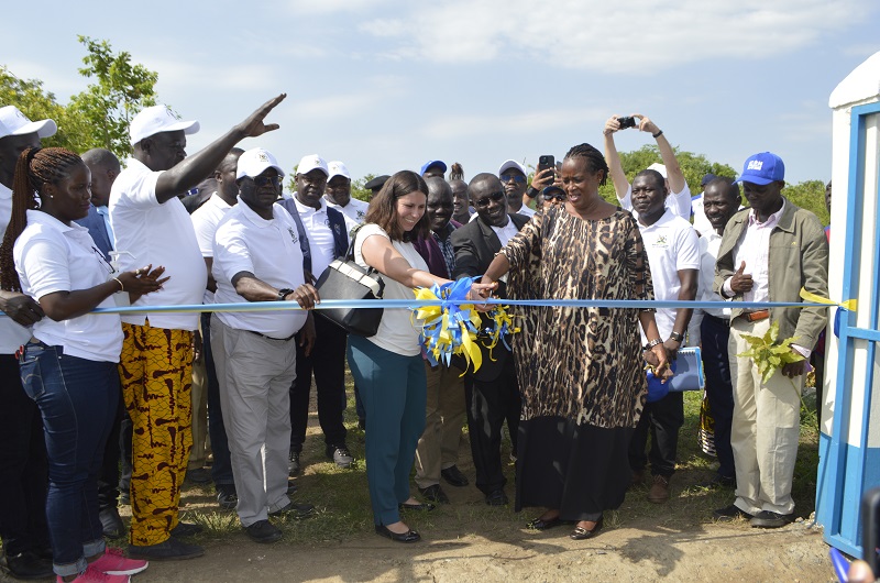 Minister Sekindi cuts a ribbon to officially unveil the one water piped system in Kati rural growth center in Madi Okollo district on Tuesday