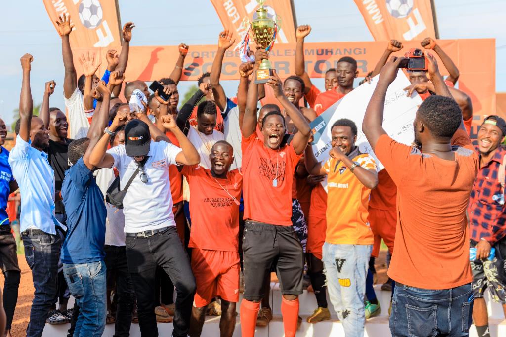 The champions, Kasubi Gold branch punters celebrate their victory with a trophy and cheque