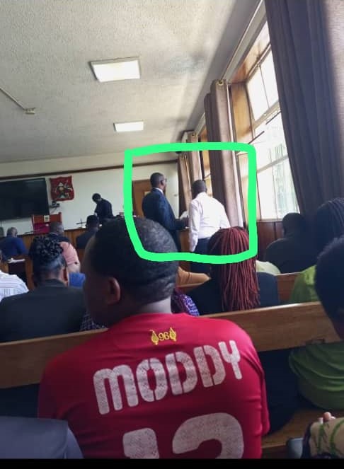 Asiimwe consulting his lawyer Kanyamuyenga (in spects) inside court on Monday